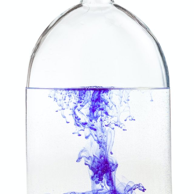 violet watercolour dissolves in water in flask